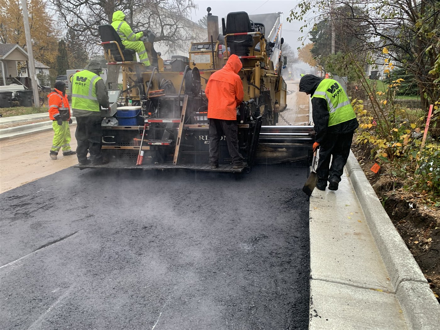 Paving crew placing new asphalt on Church Street in East Troy