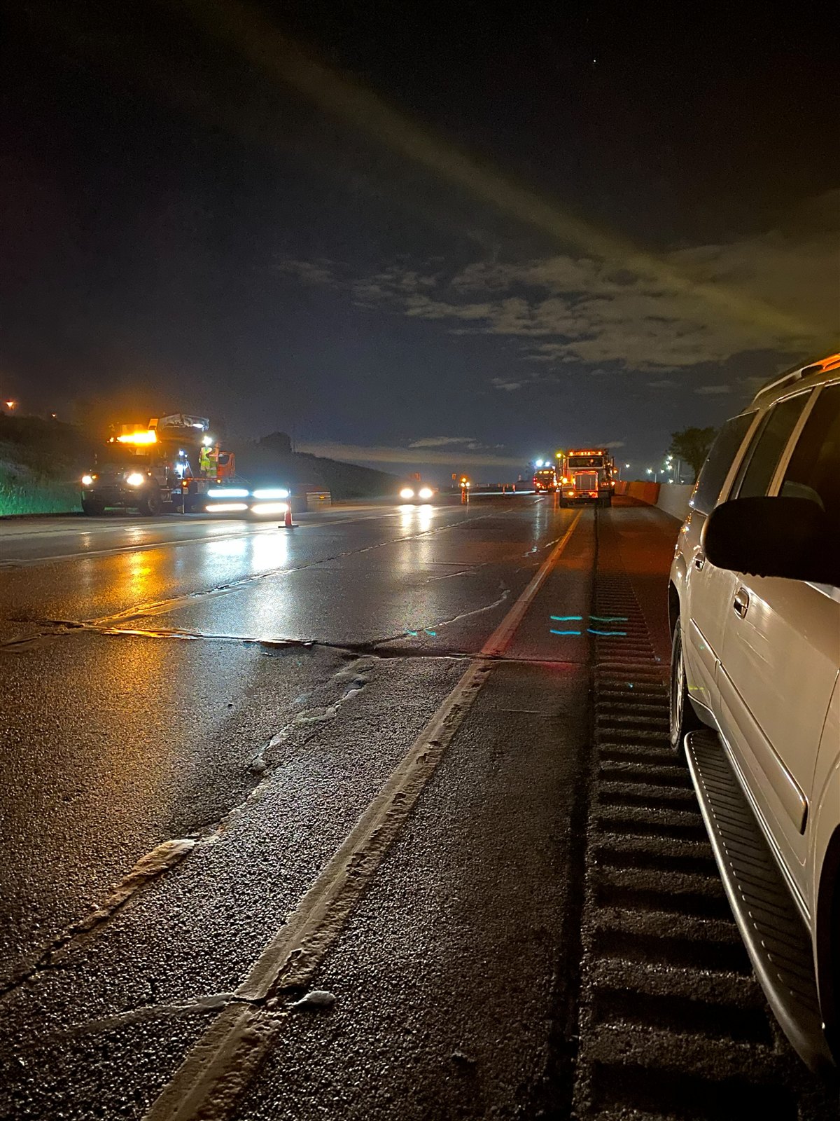 Wet IH-94 corridor at night with the maintenance convoy working ahead