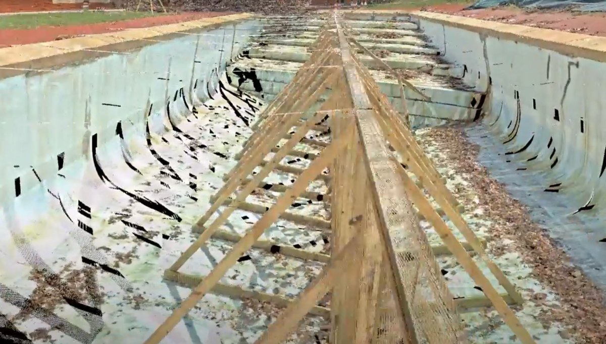 Point-cloud scan inside the drained hull-shaped pool showing curved undercut walls