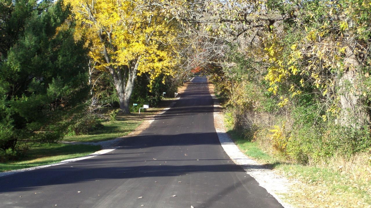 Renewed tree-lined rural pavement on Piper Road in the Town of Eagle